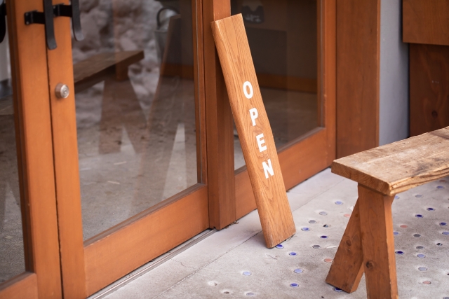 「open」と書かれたコーヒー販売店の木製看板