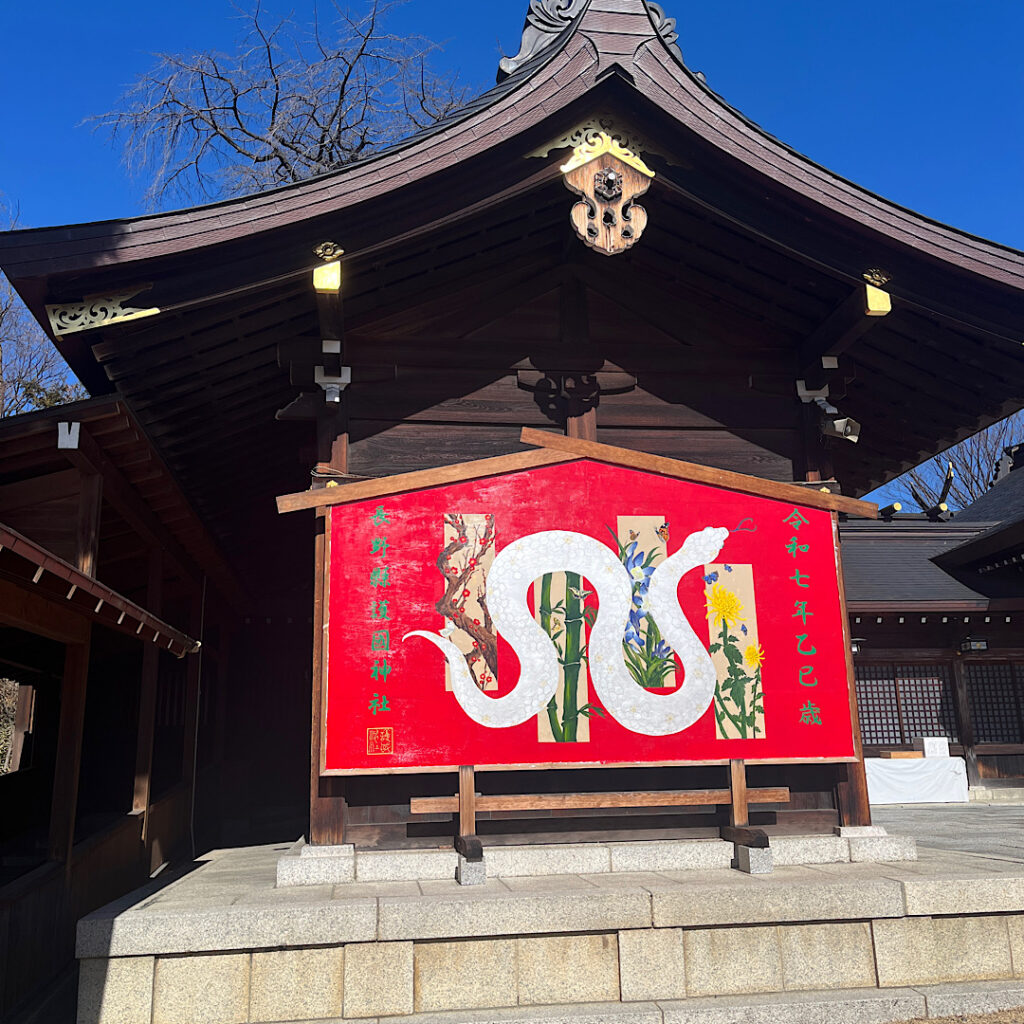 長野縣護国神社の本殿左わきに朱色の巨大絵馬が立っている